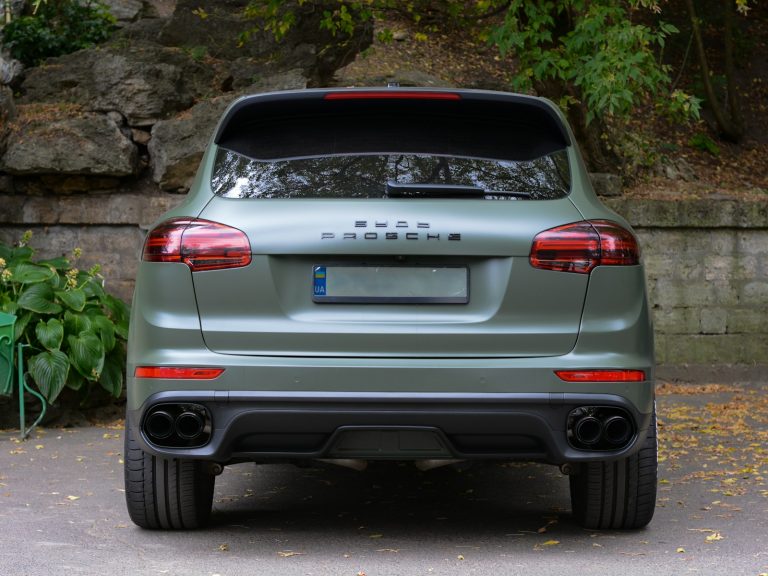 The rear end of a car parked in a driveway